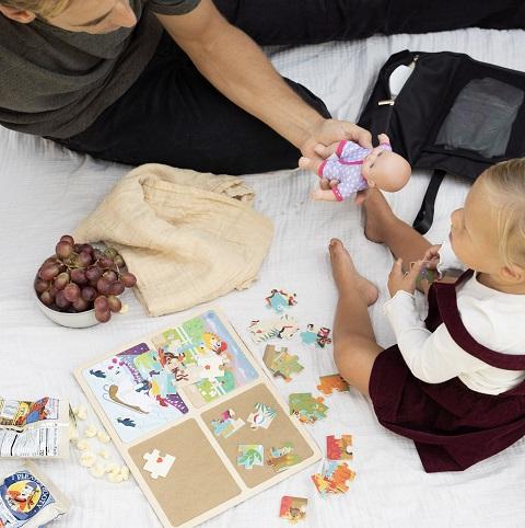 Dad and his little daughter choosing toys to go into the diaper bag